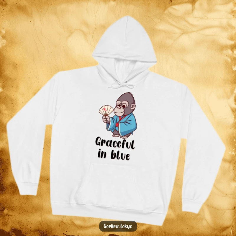 Funny hoodie design: a gorilla wearing a blue formal kimono, gracefully holding a delicate fan, exuding calm.